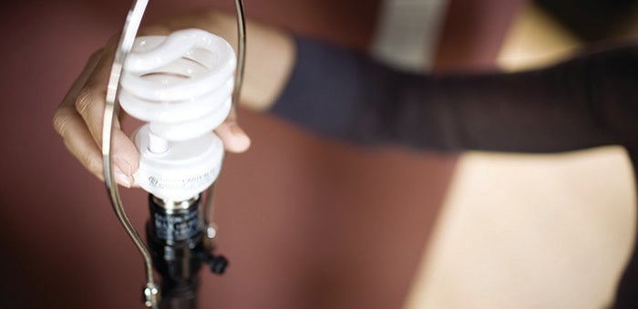 Woman changing light bulb
